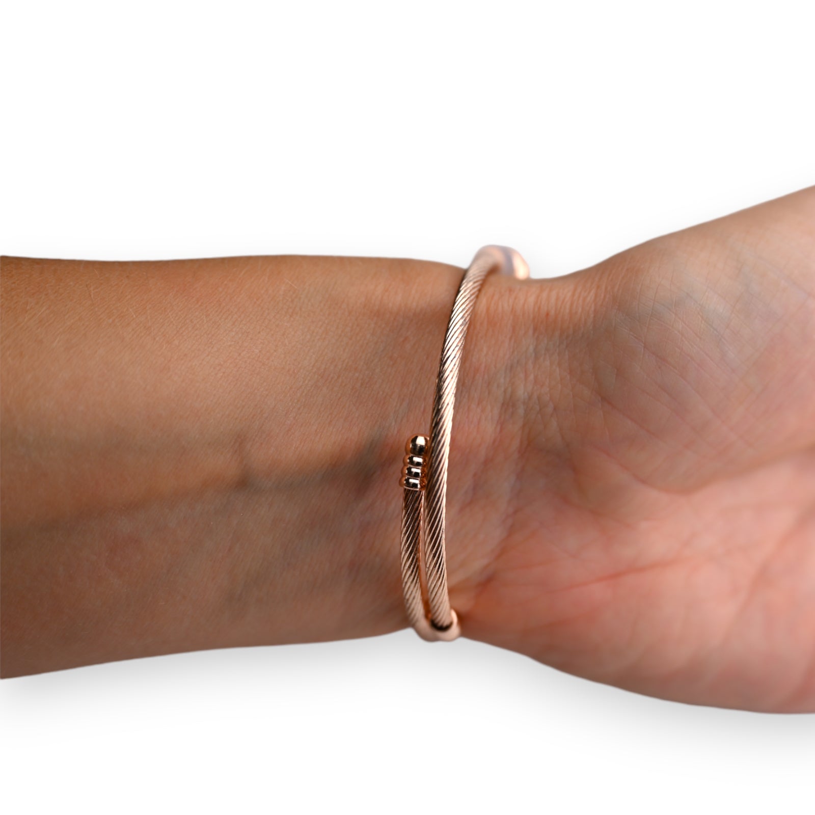 Elegantes Rosegold-Armreif aus Kupfer mit feinem Muster, am Handgelenk getragen, schlichtes und modernes Design