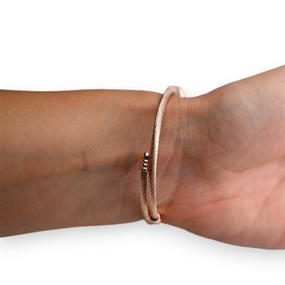 Elegantes Rosegold-Armreif aus Kupfer mit feinem Muster, am Handgelenk getragen, schlichtes und modernes Design