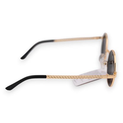 Runde Sonnenbrille mit goldenem Rahmen, schwarzen Bügeln und einer dekorativen Kettenverzierung am Seitenteil