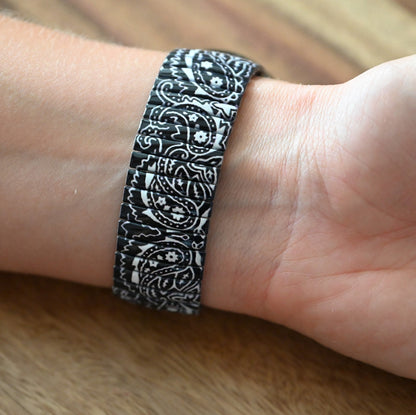 Armband mit schwarz-weißem Paisley-Muster auf Handgelenk, elastisches Design mit detaillierten Ornamenten