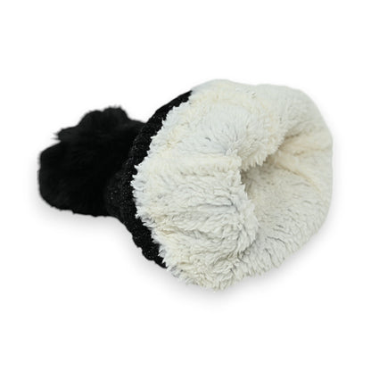 Schwarze Cord-Mütze mit weißem Fleece-Futter, umgedreht liegend. Kontrastreich, kuschelig und warm für den Winter.