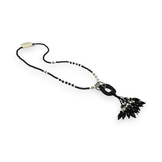 Lange schwarze Halskette mit weißen Perlen, rundem Anhänger und schwarzer Quaste. Eleganter Modeschmuck für Damen.