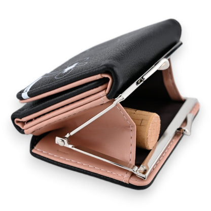 Schwarze Ledergeldbörse mit rosa Innenfutter, Münzfach und Metallverschluss, geöffnet auf weißem Hintergrund