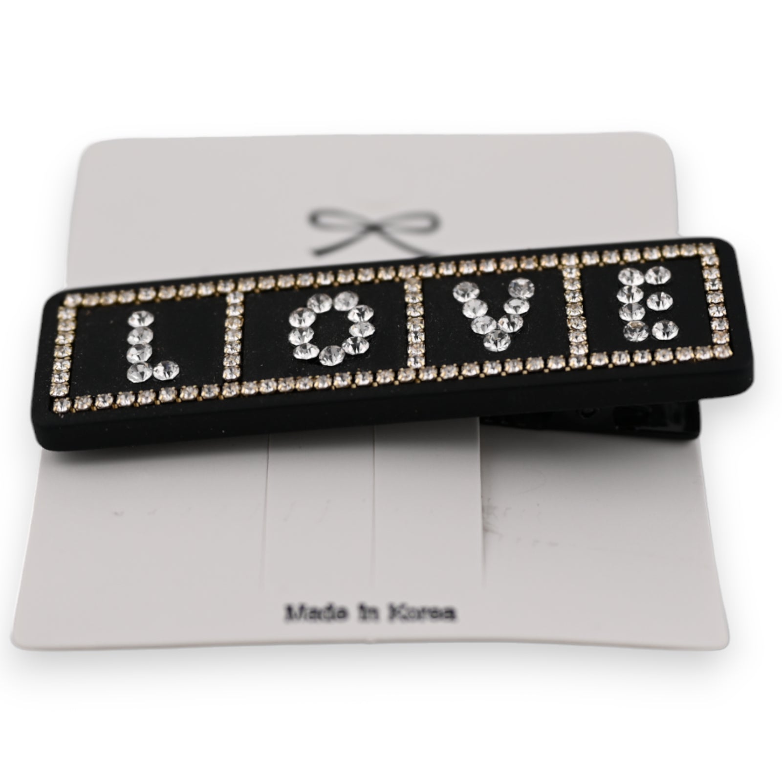 Schwarze Haarspange mit LOVE-Schriftzug aus Strasssteinen, auf weißer Karte mit Made in Korea Aufdruck