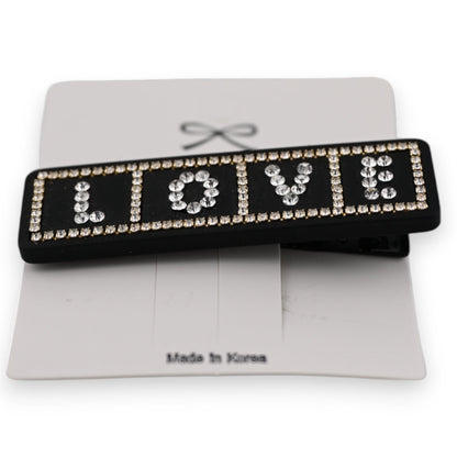 Schwarze Haarspange mit LOVE-Schriftzug aus Strasssteinen, auf weißer Karte mit Made in Korea Aufdruck