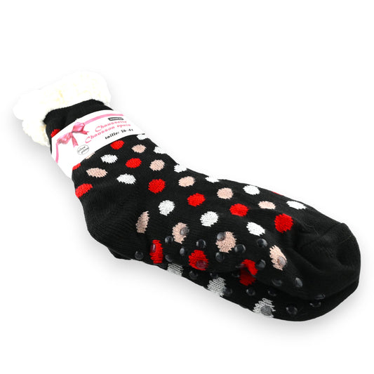 Schwarze Socken mit roten, weißen und beigen Punkten, rutschfester Sohle und Etikett. Cozy Cabin-Stil für Zuhause.