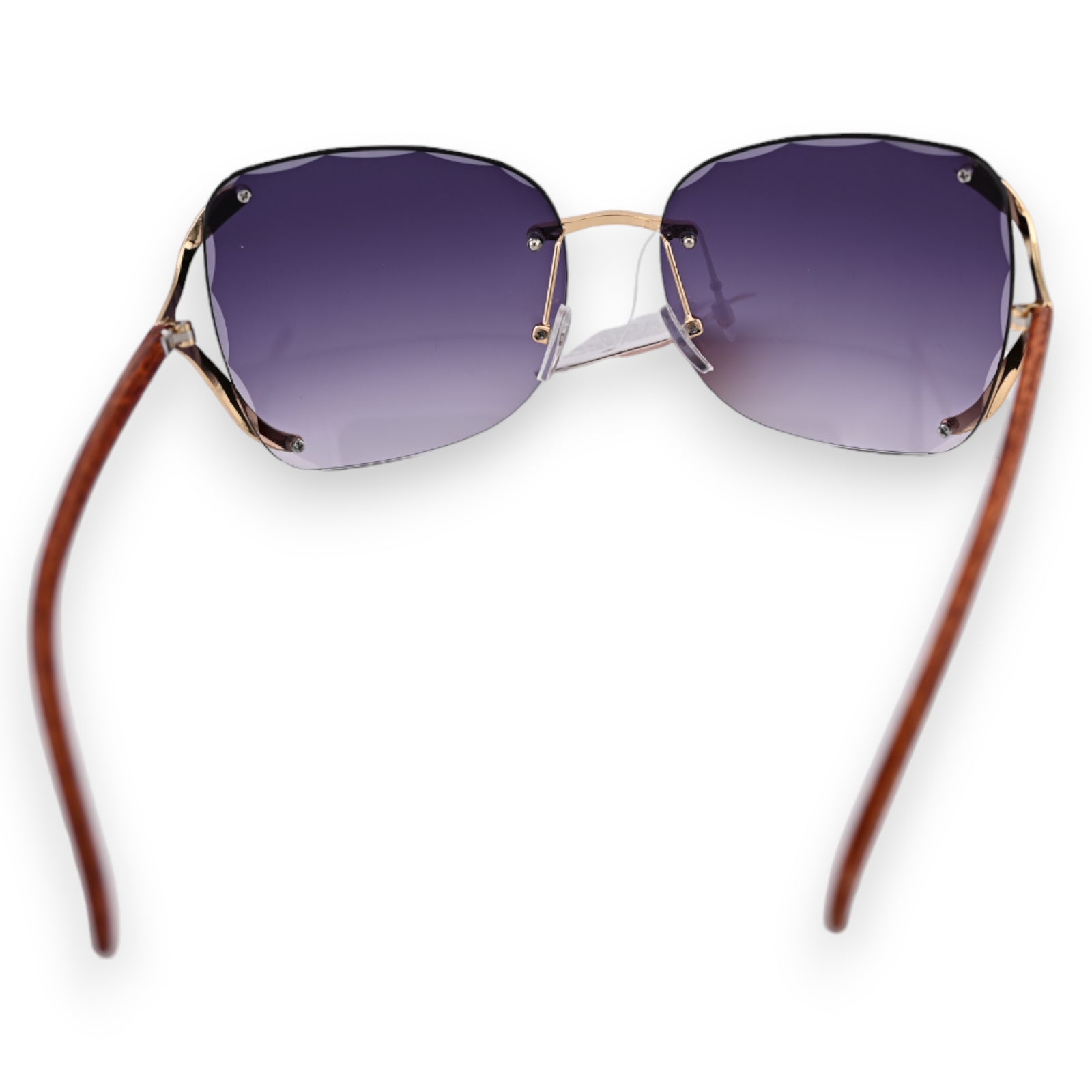 Elegante Sonnenbrille mit rauchgrauen Gläsern, goldenem Rahmen und braunen Bügeln, in einer modernen, randlosen Form