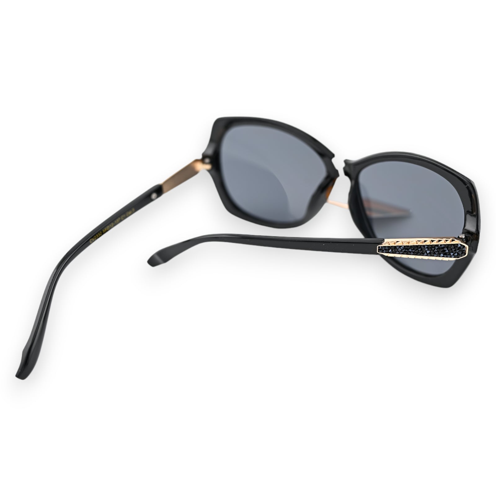 Große schwarze Sonnenbrille mit goldenem Akzent am Bügel, elegantes Design, dunkle Gläser, auf weißem Hintergrund