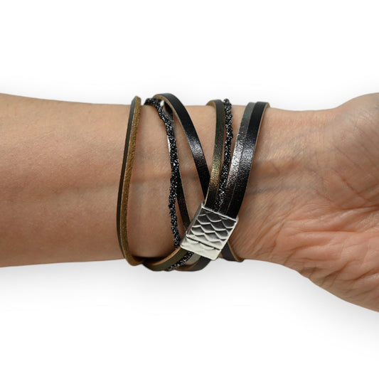 Mehrfach gewickeltes schwarzes Lederarmband mit metallischem Verschluss und glitzernden Elementen am Handgelenk
