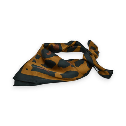 Seidiges Halstuch mit Karamell-Leopardenmuster, elegant gefaltet auf weißem Hintergrund. Modisches Accessoire.