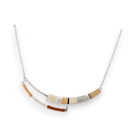 Silberne Halskette mit geschwungener Verzierung aus farbigen Elementen in Beige-, Gold- und Brauntönen an feiner Kette