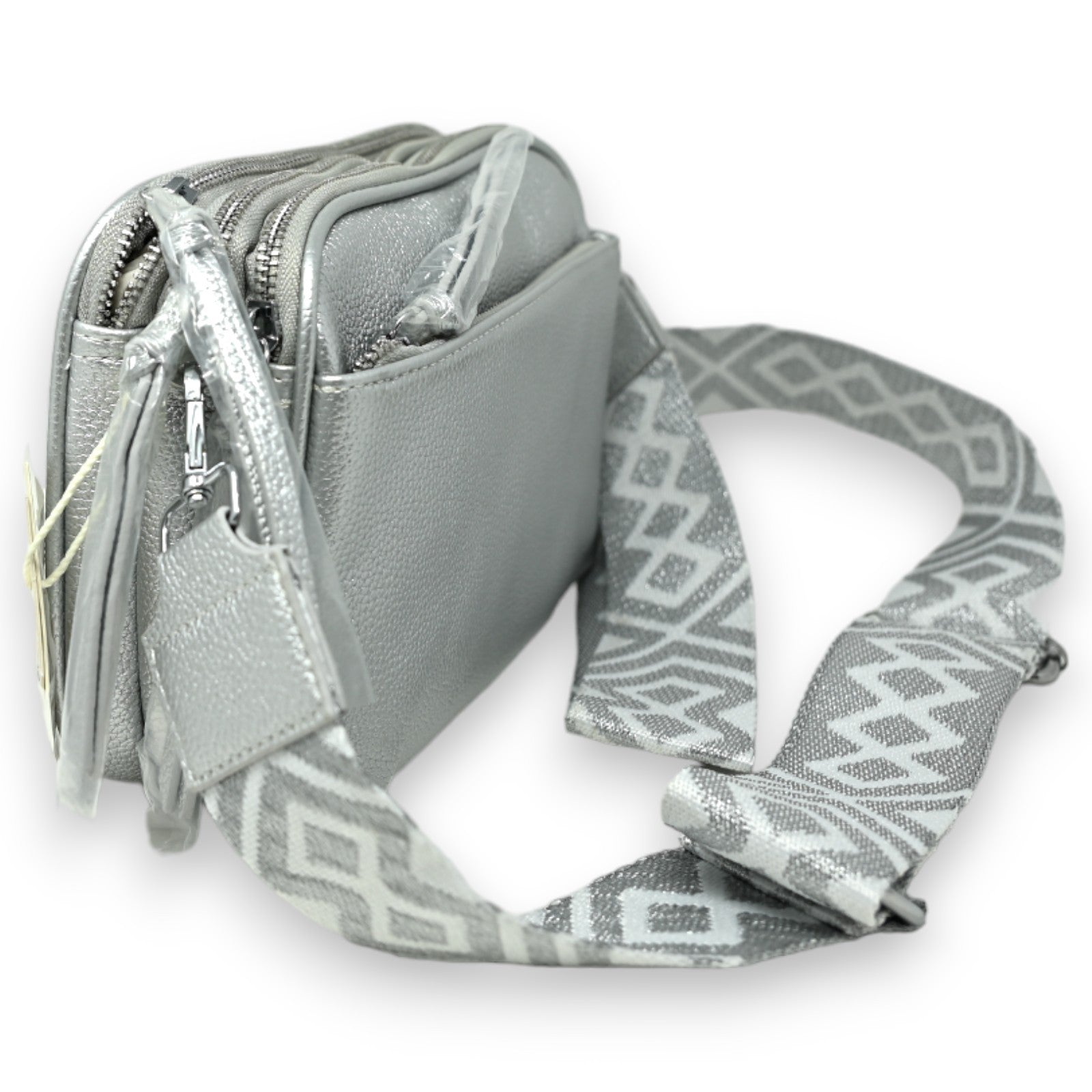 Silberne quadratische Umhängetasche mit mehreren Reißverschlusstaschen und geometrisch gemustertem Schulterriemen