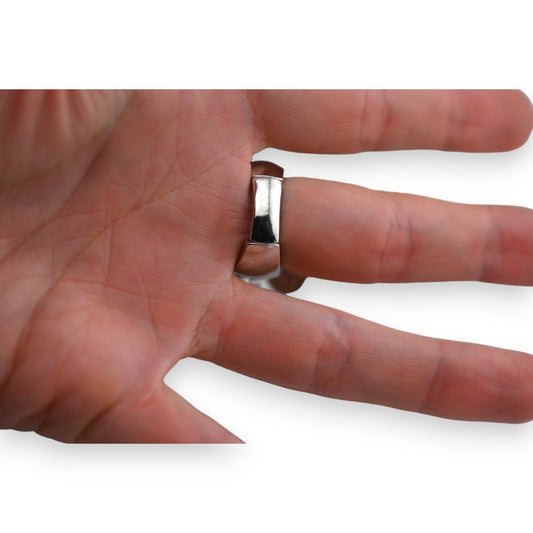 Silberner Ring an Hand, glatte Oberfläche mit abgerundeten Kanten, elegantes Design für Alltag und besondere Anlässe