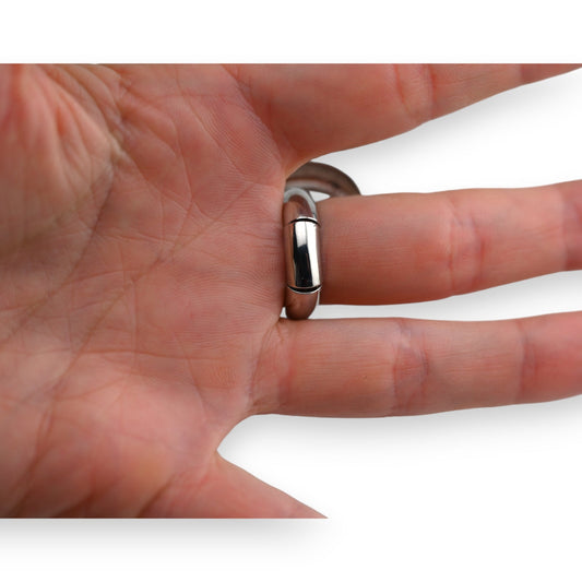 Silberner Ring mit glänzendem Einsatz am Finger einer Hand, Nahaufnahme zeigt Details und Passform