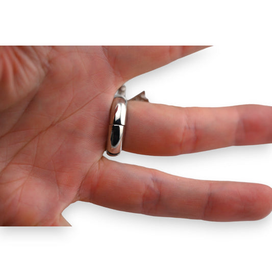Glänzender Silberring am Finger, schlichtes Design mit glattem, gewölbtem Profil, auf weißem Hintergrund