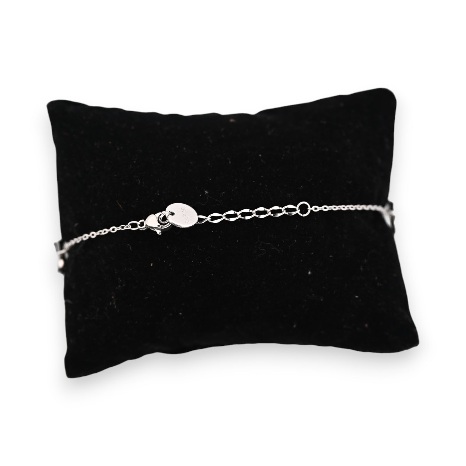 Feines silberfarbenes Stahlarmband mit Kettenverschluss auf schwarzem Samtkissen, elegantes Schmuckstück