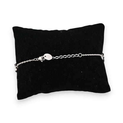 Feines silberfarbenes Stahlarmband mit Kettenverschluss auf schwarzem Samtkissen, elegantes Schmuckstück