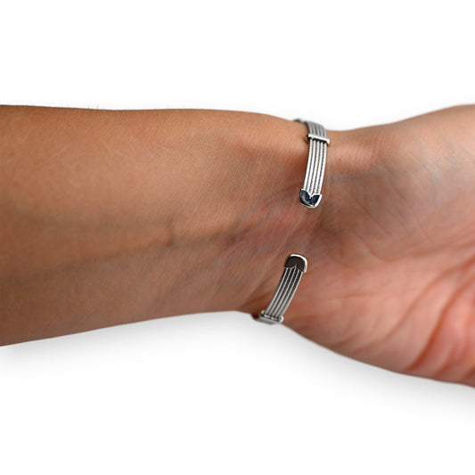 Elegantes Silberarmband mit mehreren feinen Drähten und glänzenden Enden am Handgelenk getragen