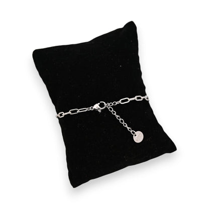 Silbernes Stahlarmband auf schwarzem Samtkissen mit kleinem Anhänger, elegantes Schmuckstück für Damen