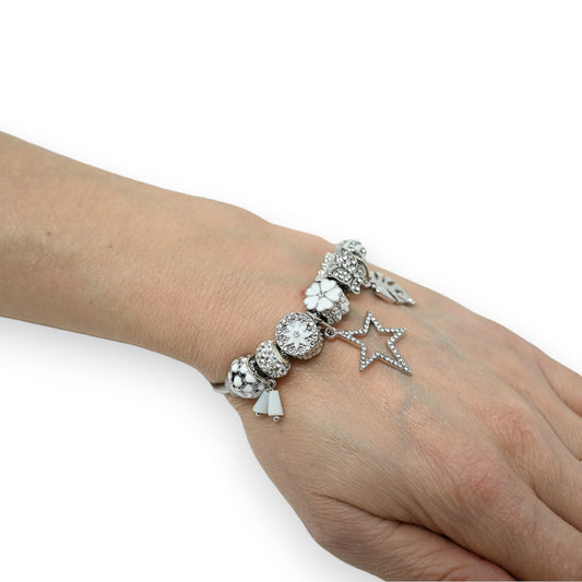 Silbernes Charm-Armband mit weißen Blumen, Strasssteinen und Stern-Anhänger am Handgelenk einer Frau