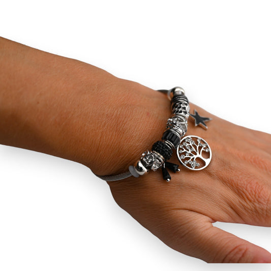 Silbernes Charm-Armband mit schwarzen Elementen, Baum des Lebens Anhänger und Stern-Tattoo auf Handgelenk