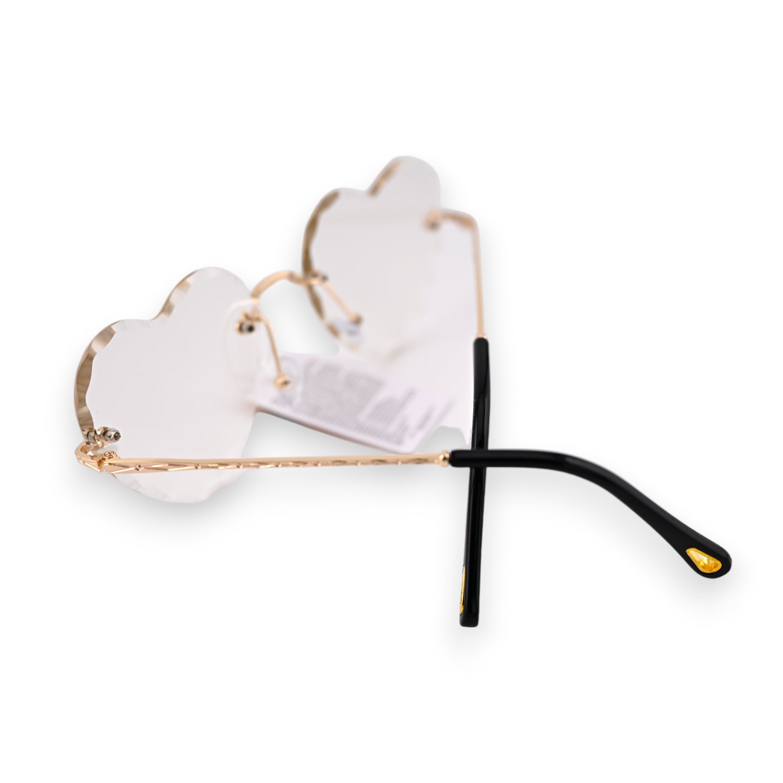 Transparente weiße Herz-Sonnenbrille mit goldenem Rahmen und schwarzen Bügeln, seitlich auf weißem Hintergrund