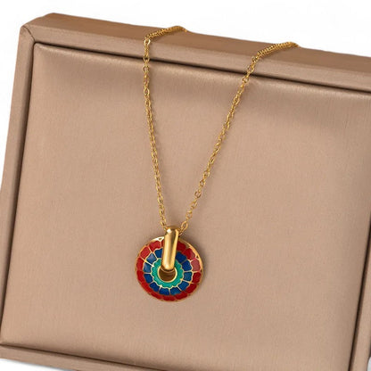 Goldene Halskette mit buntem Mosaik-Medaillon-Anhänger auf beigem Schmuckkästchen, elegantes Accessoire